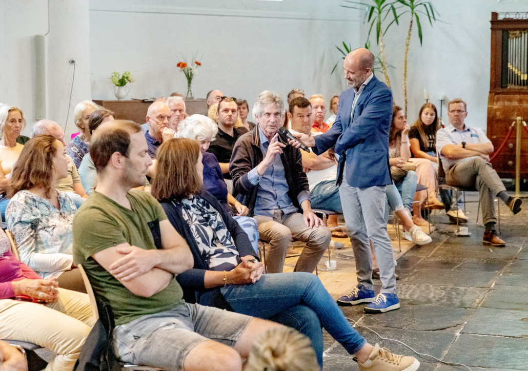 Arend de Geus met microfoon in de hand leidt een participatie bijeenkomst